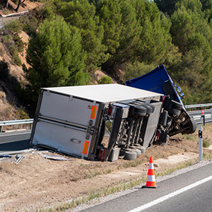 Truck with an accident refrigerated semi-trailer, overturned by the exit of the highway in the median of the highway.